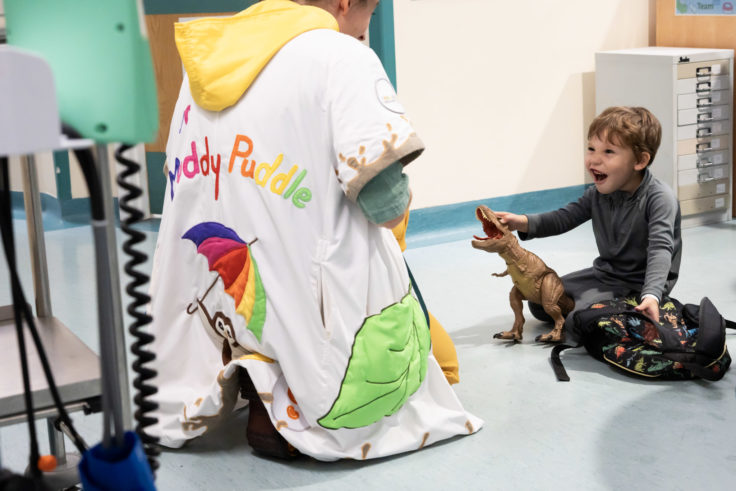 Little boy and giggle doctor playing with dinosaur toys